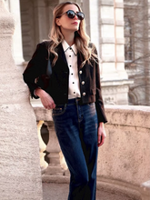 a lady wears a v-neck black crop jacket with white shirt